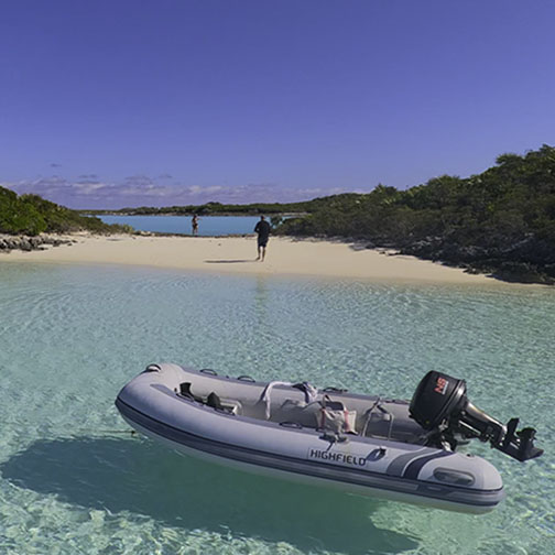 Golden sunset view from Bon Bida catamaran deck showing dramatic sky with yellow and orange clouds reflected on calm waters, with boat rigging and another sailing vessel silhouetted in distance - the magical moments that await on Breaking Free Sailing charters