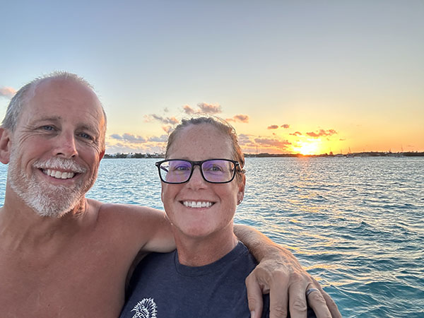 Captain Rob and Admiral Emily Edgcombe enjoying a moment together on a pristine sandbar near Pipe Cay in the Bahamas, representing their new life of freedom and adventure after breaking free from corporate constraints